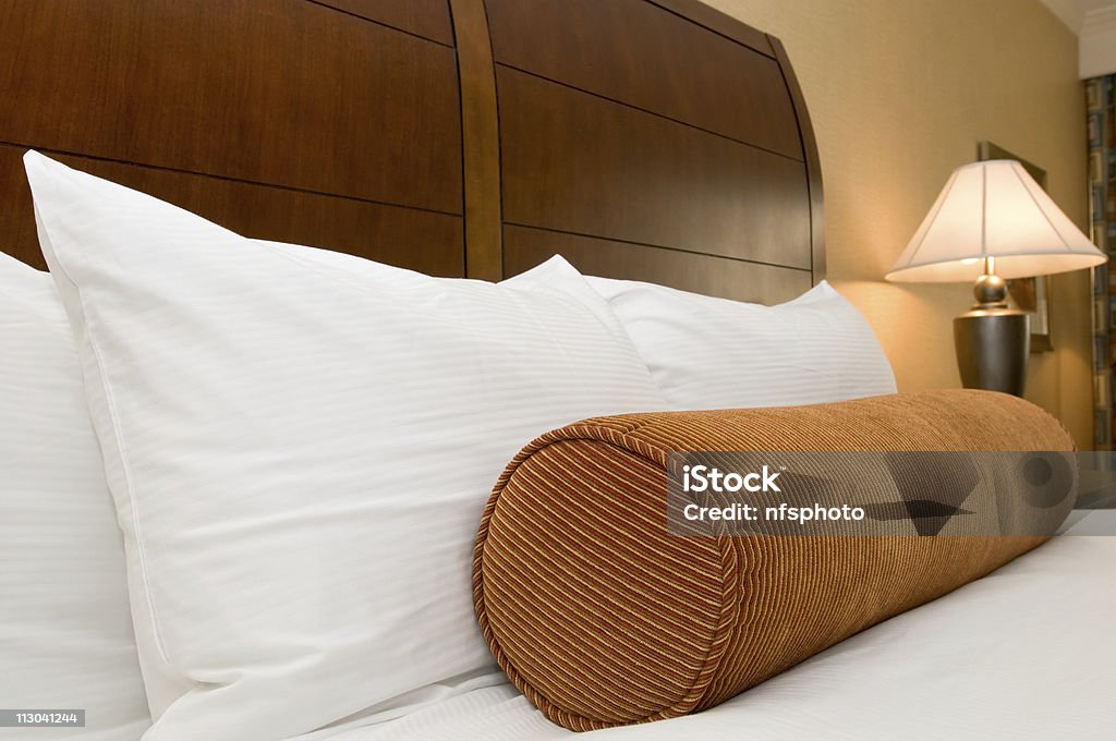 Almofadas sobre a cama no quarto de hotel - Foto de stock de Aconchegante royalty-free