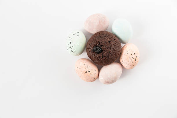 istock Colored eggs and cupcake.Minimalist style.Flat lay.White background. 1130412483