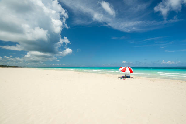 istock red parasol on the Caribbean beach 1130418745