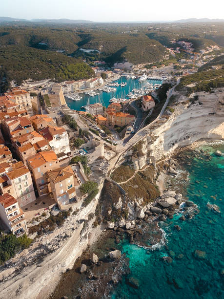 dron strzał śródziemnomorskiego nadmorskiej miejscowości bonifacio, korsyka. miasto znajduje się na skraju klifu nad błękitnym oceanem. - waters edge nature water wave zdjęcia i obrazy z banku zdjęć