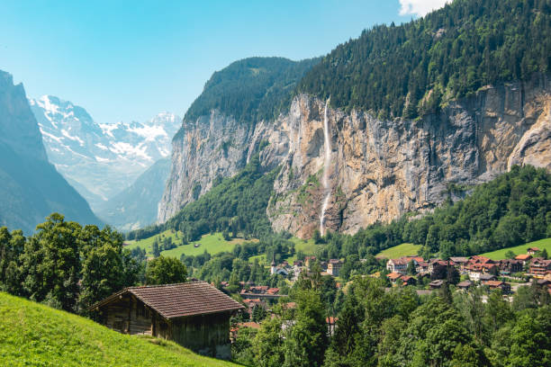 die schöne kleinstadt lauterbrunnen in den schweizer alpen, im kanton bern gelegen, mit dem ikonischen staubbach-wasserfall im hintergrund. - swiss culture european alps eiger mountain range stock-fotos und bilder