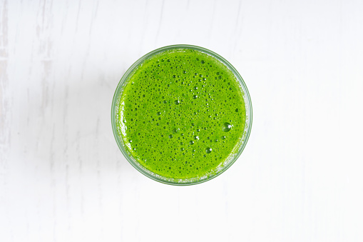 Fresh green smoothie with spinach on wooden background