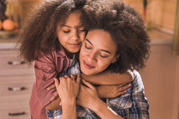 istock Affectionate black mother and daughter embracing with eyes closed. 1130428556
