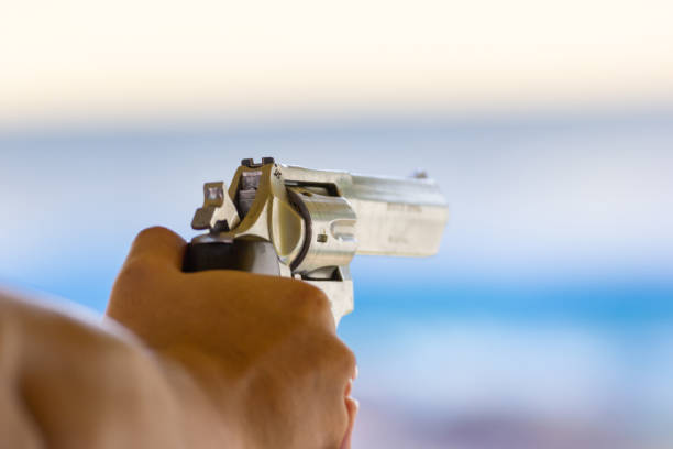 istock Man hold a gun ready to shoot  practicing shooting in the park 1130429124