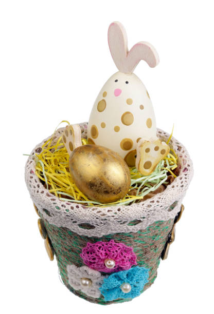 istock Cheerful handmade wooden Easter bunny guards a golden quail egg. Isolated 1130433506