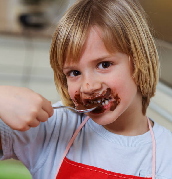 kleiner junge schokolade mit löffel zu essen - child chocolate ice cream human mouth stock-fotos und bilder