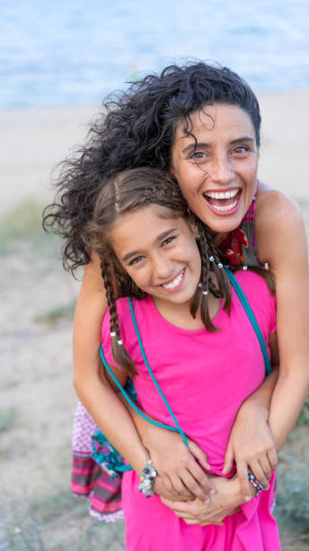 istock Mother and daughter having fun on the beach 1130440638
