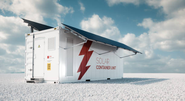 istock Solar container unit. 3d rendering concept of a white industrial battery energy storage container with mounted black solar panels situated on white gravel in empty landscape in sunny weather. 1130440824