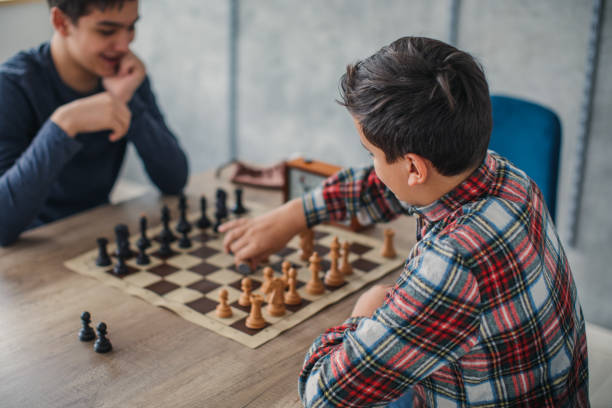 istock Boys playing chess in chess school 1130442254