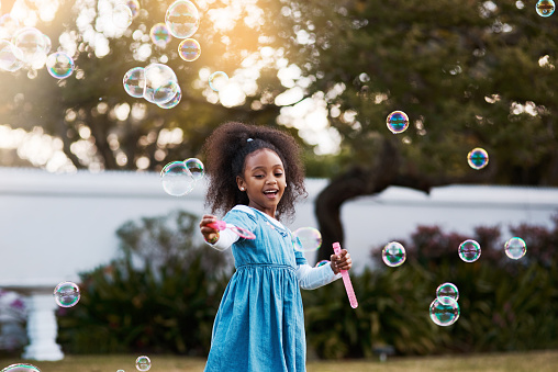 Shot of an adorable little girl playing with bubbles outdoors