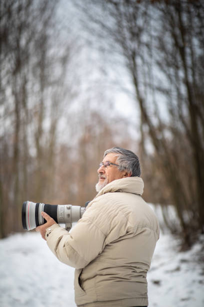 istock Senior man devoting time to his favorite hobby - photography 1130442539