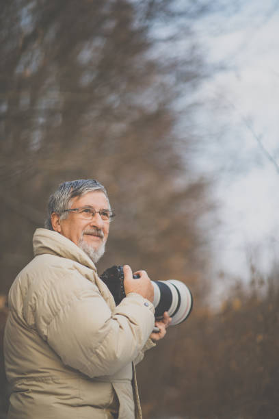 istock Senior man devoting time to his favorite hobby - photography 1130442552