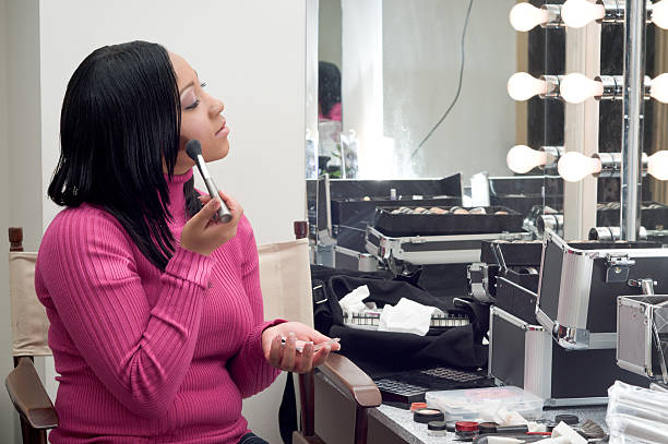 istock Young woman applying makeup, looking at mirror 113044383