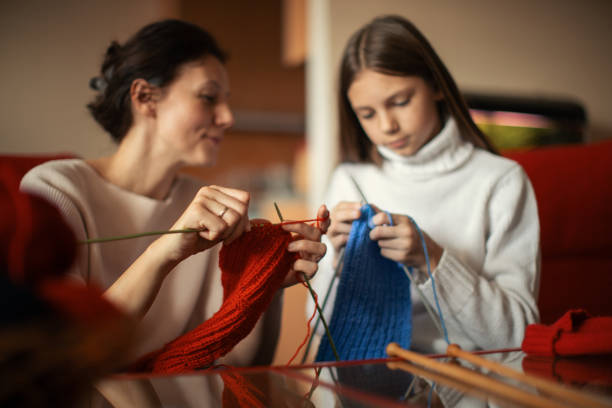 istock Mother and daughter knitting at home 1130443982