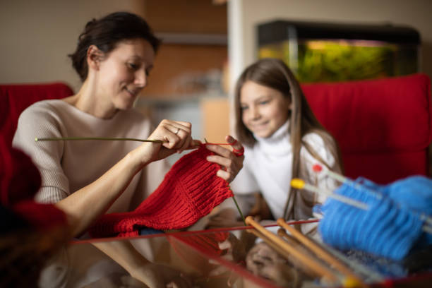 istock Mother and daughter knitting at home 1130444052