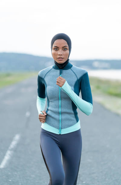 Asian sportswoman with hijab jogging on the road Asian sportswoman with hijab jogging on the road middle eastern culture photos stock pictures, royalty-free photos & images