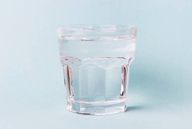 istock Glass cup with water on a blue background 1130447050