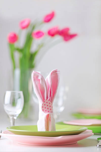 istock Happy easter. Decor and table setting of the Easter table is a vase with pink tulips and dishes of pink and green color. 1130447603