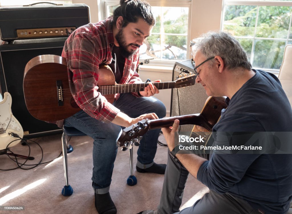 Hispanic Young Man Teaching Mature Caucasian Man to Play Guitar North Vancouver, British Columbia, Canada Music Stock Photo