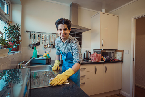 Adolescente limpiando la cocina photo