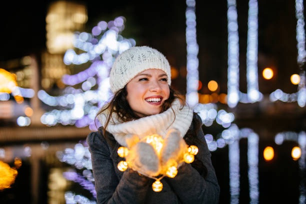 istock Young woman holding Christmas lights 1130455580