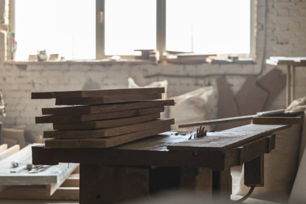 istock Design wood concept. Old fashioned rusty carpenters tools lying under wooden tile boards composition. Photo of wooden plank board on saw table in empty garage or workroom interior 1130455637