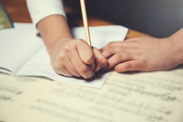 istock girl hand pen with music book 1130455776