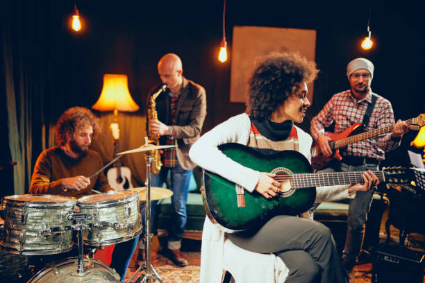 istock Mixed race woman singing and playing guitar 1130456631