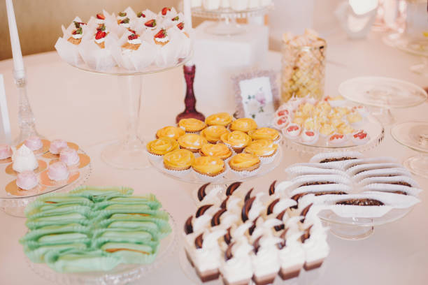 istock Delicious eclairs,macaroons,cupcakes, desserts and sweets on table party at wedding reception. White and pink stylish candy bar. Christmas and New Year feast. Celebrations and party 1130459721