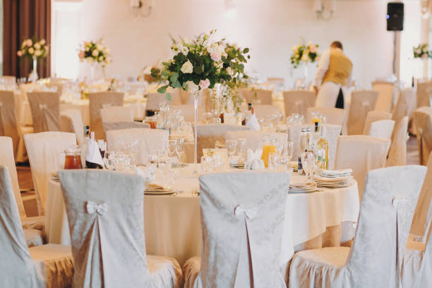 istock Stylish decorated tables with roses bouquets, plates,glasses, cutlery at wedding reception. Luxury catering. Christmas and New Year feast. Celebrations and party concept. 1130460021