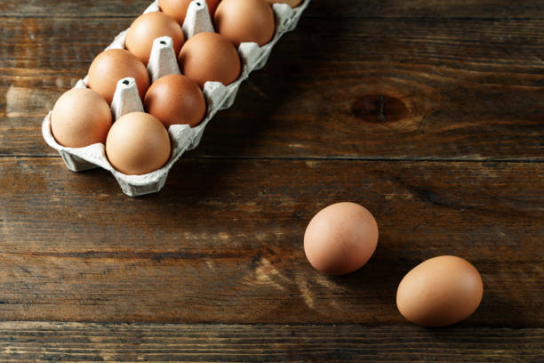 istock chicken eggs in a paper tray on wooden background. 1130460198