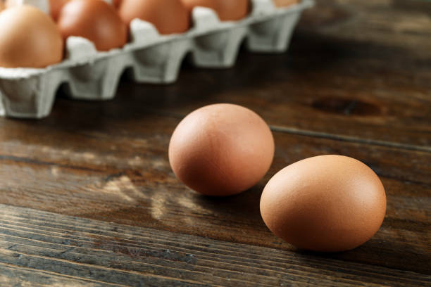 istock chicken eggs in a paper tray on wooden background. 1130460211