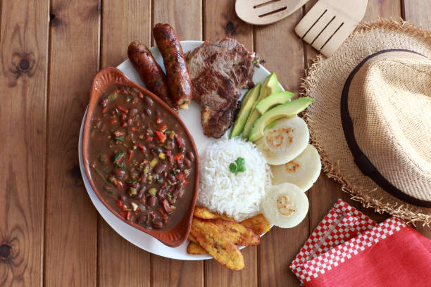 repas colombien avec steak arepa riz oeuf saucisse bandeja paisa - bandeja paisa photos et images de collection