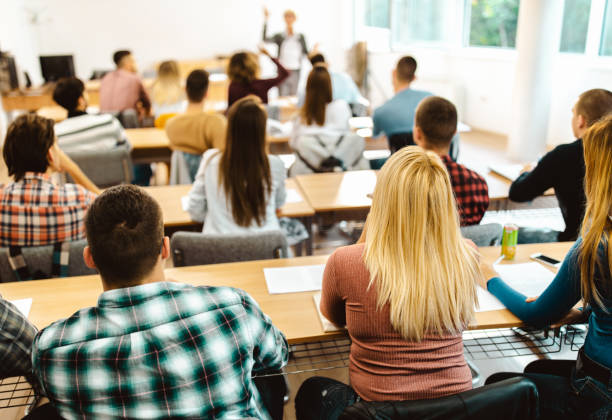 istock Back view of college students attending a class at lecture hall. 1130461467