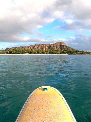 Canoes and populars surfbreak in Waikiki with a perfect view on the gigantic crater and the Diamond Head on a rather cloudy day.