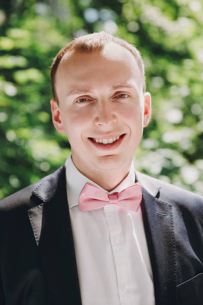Stylish Happy Groom Posing In Pink Bow Tie And Black Suit Outdoors Getting  Ready In The Morning Before Wedding Ceremony Rich Businessman Smiling Stock  Photo - Download Image Now - Istock