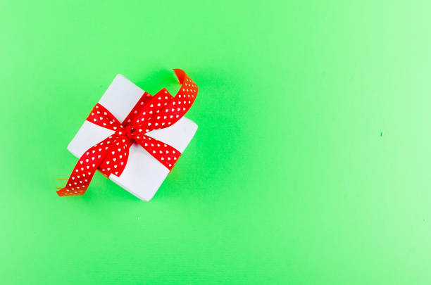 istock gift box with a bow on a green background 1130462650