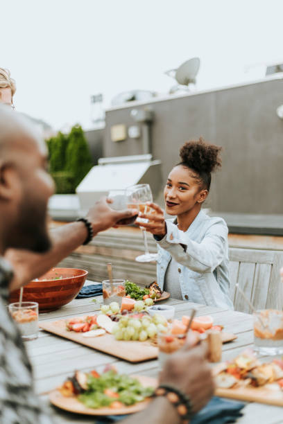 istock Friends clinking wine glasses at a rooftop party 1130463909