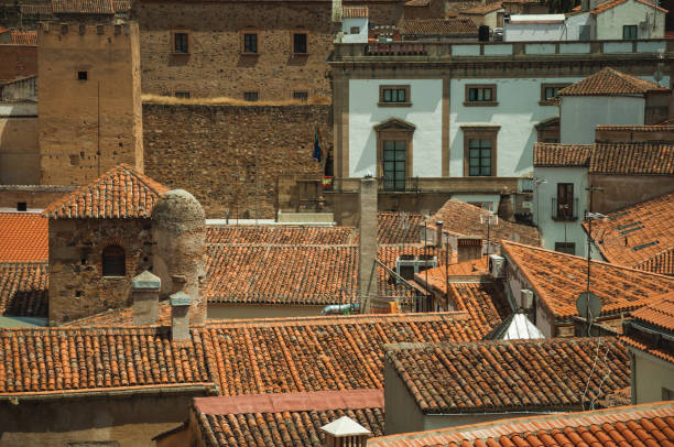 Close-up of several old building rooftops and chimneys, in a sunny day at Caceres. A cute and charming town with a fully preserved medieval city center in western Spain.