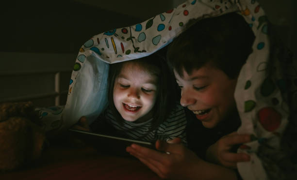 istock Brothers looking at the tablet in the dark 1130466907