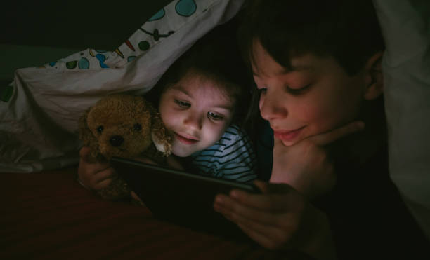 istock Brothers looking at the tablet in the dark 1130466908