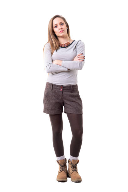 Serious young cute woman in second hand hipster style clothes looking at camera with crossed arms Serious young cute woman in second hand hipster style clothes looking at camera with crossed arms. Full body isolated on white background. women young women standing full length stock pictures, royalty-free photos & images