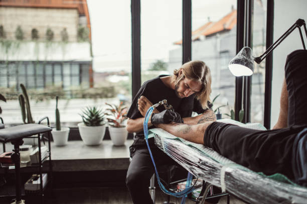 istock Man getting a new tattoo on leg 1130470084