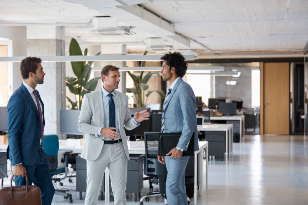 istock Businessman talking with colleagues in office 1130470372