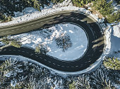 Winding road through the winter forest - aerial view