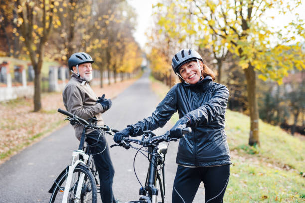 istock Active senior couple with electrobikes standing outdoors on a road in nature. 1130470448