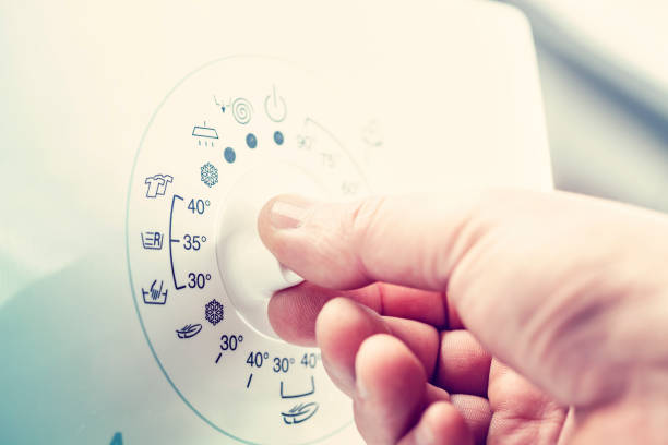 pessoa, girando o dial na máquina de lavar roupa - thermostat dial human hand white - fotografias e filmes do acervo
