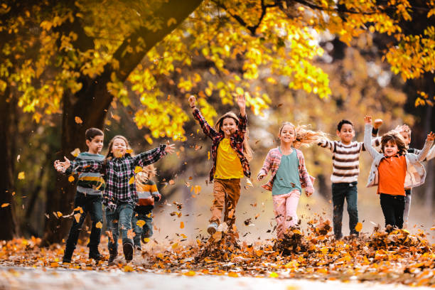 istock Playful children having fun while running in autumn day at the park. 1130471588