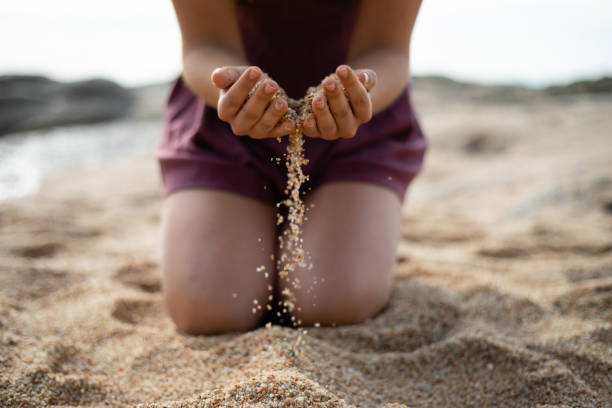 istock Kneel girl dropping sand from both hands 1130476882