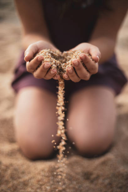 Kneel girl dropping sand from both hands